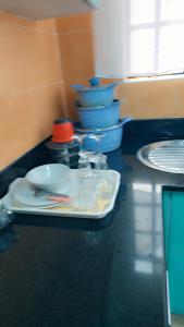 a counter with plates and dishes on a table at Kerry Luxury Stays in Athi River