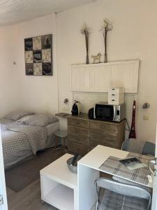 a bedroom with a bed and a microwave on a dresser at Studio "Jakar" près de Toulouse in Saint-Jean