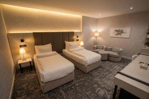 a hotel room with two beds and a couch at Youssif Hotel in Dakākīn Ḩamīd +37 photos
