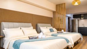 two beds in a room with a kitchen at Tripleview luxurious eton baypark manila in Manila +27 photos