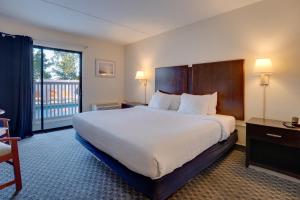 a hotel room with a large bed and a balcony at The Bay Resort in Dewey Beach +38 photos