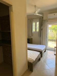 a bedroom with two beds and a window at Tarbouche House Dahab in Dahab