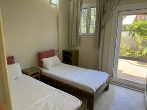 two beds in a room with a window at Tarbouche House Dahab in Dahab +8 photos