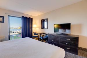 a hotel room with a bed and a flat screen tv at The Bay Resort in Dewey Beach
