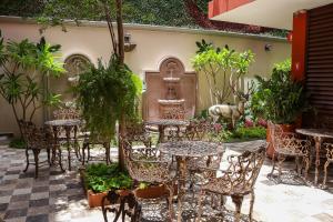 an outdoor patio with tables and chairs and plants at Gran Vila Nai Boutique Hotel in Guadalajara
