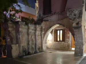 an archway in a stone building with a window at LUM Luxury Studios in Rethymno