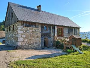 an old stone house with a cat on the roof at L'Entre Monts in Saint-Pierre-dʼEntremont