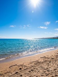 a beach with the sun shining on the water at DreamHouse in Cholpon-Ata