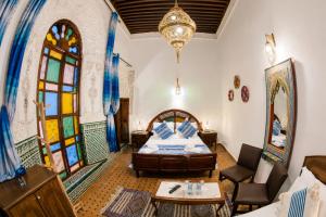 a bedroom with a bed and a chandelier at Riad Nassim Fez in Fez