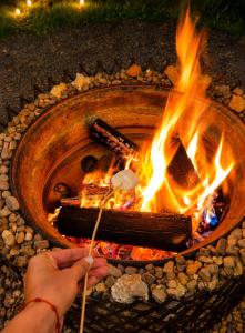 a person is lighting a fire in a fire pit at La Casita de Carpintero in Cucunubá