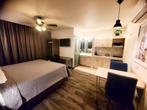 a bedroom with a bed and a desk and a kitchen at Barrio Inn Padre Mier Hostal & Suites in Monterrey