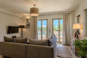 a living room with a couch and a tv at The Olive Grove Kardamyli in Kardamyli