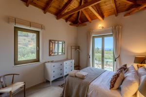 a bedroom with a bed and a window and a chair at The Olive Grove Kardamyli in Kardamyli +138 photos