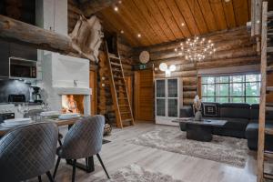 a log cabin living room with a couch and a fireplace at Villa RukanKelo in Ruka