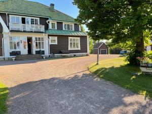 a house with a tree and a driveway at Trunnagården in Orsa
