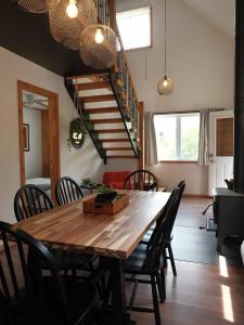 a dining room with a wooden table and chairs at Le Lac Apaisant - Rustic Haven by the Water in Saint-Calixte