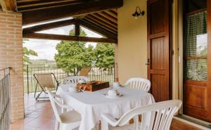a white table and chairs on a balcony at Poggio Mille in Castiglione del Lago