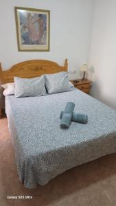 a bed with a blue slipper on top of it at Miramar Playa confortable apartament in Miramar