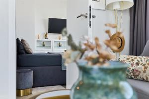 a living room with a couch and a vase with flowers at WAVE Seaview in Międzyzdroje