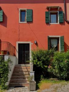 a red building with stairs in front of it at Casa Olivia Bardolino - Garda Lake in Bardolino