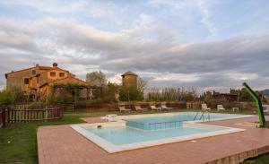 a swimming pool in front of a house at Poggio Mille in Castiglione del Lago