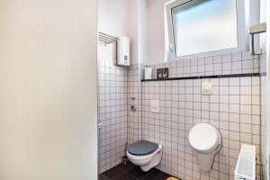 a small bathroom with a toilet and a window at Loftwohnung 140 qm mit Parkplatz, Wlan, 2 Schlafzimmer, Terrasse , Wäscheservice in Groß-Umstadt +7 photos