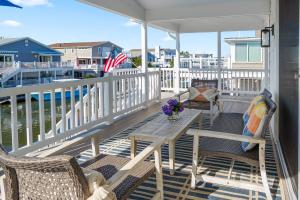 a porch with chairs and a table with flowers on it at 47 Oyster Bay Dr, Fenwick Island in Fenwick Island