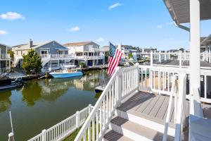 a balcony with an american flag next to a marina at 47 Oyster Bay Dr, Fenwick Island in Fenwick Island