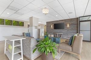 a living room with a couch and chairs and a tv at Best Western Plus Ocean City in Ocean City