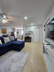 a living room with a blue couch and a kitchen at Inn At Juzani Boutique Hotel in Lambeau