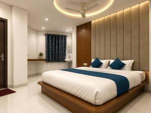 a bedroom with a large bed with blue pillows at hotel ak grand in Mangalore
