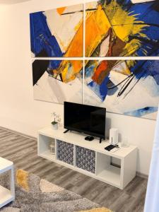 a living room with a tv and a painting on the wall at Balchik Sea View Studio in Balchik