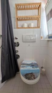a bathroom with a toilet with its lid up at Gemütliche 1-Zimmer-Wohnung im Hildesheimer Wald in Diekholzen
