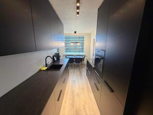 a kitchen with white cabinets and a sink and a table at Vesturgata 8 KEF in Keflavík