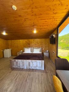 a bedroom with a large bed in a wooden room at Hotel Mirioni in Oni