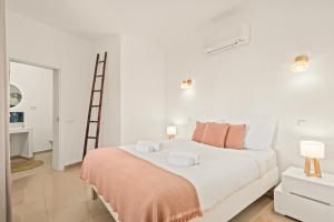 a white bedroom with a large bed and a ladder at Vilamoura 4-Bedroom Private Pool Villa in Vilamoura
