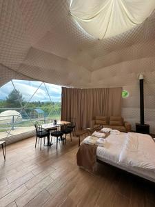 a bedroom with a bed and a table and chairs at Shaori Space - შაორი სფეისი in Nikortsminda