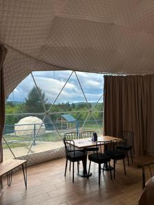a room with tables and chairs and a large window at Shaori Space - შაორი სფეისი in Nikortsminda
