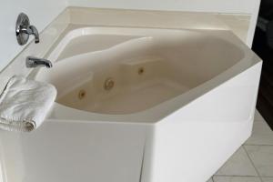 a white bath tub in a white bathroom at Bilmar Inn & Suites Dell Rapids Near Sioux Falls in Dell Rapids