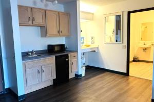 a kitchen with a sink and a microwave at Bilmar Inn & Suites Dell Rapids Near Sioux Falls in Dell Rapids