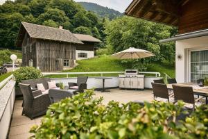 a patio with a table and chairs and an umbrella at Haus Bergharmonie in Tschagguns