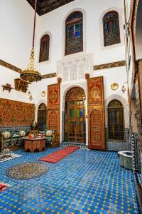 a large room with a blue tile floor and wooden doors at Riad Nassim Fez in Fez