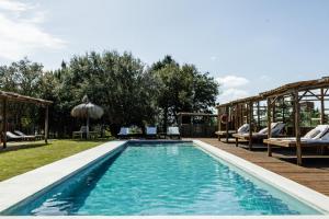 a swimming pool in a yard with a wooden deck at Ponte Pedra Melides -Nature & Ocean- Adults Only in Melides