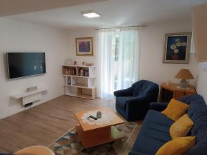 a living room with a blue couch and a tv at Garden apartment Vanya in Split