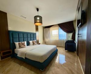 a bedroom with a large bed with a blue headboard at Palace rif zicht in Nador +106 photos