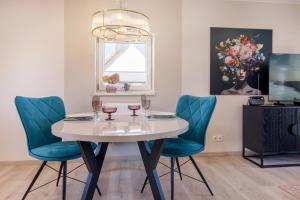 a dining room with a white table and blue chairs at Ferienwohnung Rosen am Meer in Sassnitz