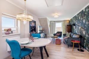a living room with a white table and blue chairs at Ferienwohnung Rosen am Meer in Sassnitz