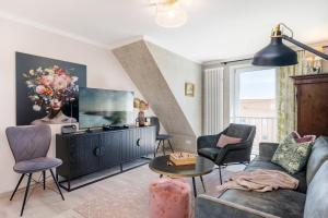 a living room with a couch and a flat screen tv at Ferienwohnung Rosen am Meer in Sassnitz
