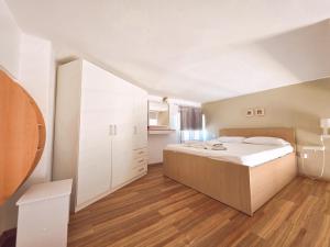 a bedroom with a large white bed and wooden floors at Loft Suites - by Avelink in Spata +7 photos