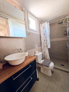 a bathroom with a sink and a toilet and a mirror at Loft Suites - by Avelink in Spata